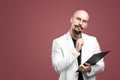 Balded man with mustache and beard in a business suit holding clipboard and pen isolated background.Concept of teacher