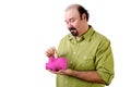 Balding man putting money in piggy bank