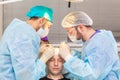 Baldness treatment. Hair transplant. Surgeons in the operating room carry out hair transplant surgery. Surgical