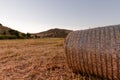 Bale of hay close-up during Golden hour, with hills in the background