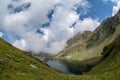 Balea lake and Balea Hotel in spring time with clouds Royalty Free Stock Photo