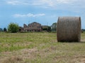 Bales of Hay in the Countryside and a Ruined Farmhouse in the background