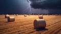Bales of hay on the field during a lightning storm. Force of nature landscape. Agricultural field with straw bales and lightning