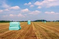 Bales of hay packed with foil and stacked on mown grassland Royalty Free Stock Photo