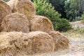 Bales of yellow golden straw stacked in a pile at the farm with blue sky on the background . Food for Farm animals. Royalty Free Stock Photo