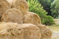 Bales of yellow golden straw stacked in a pile at the farm with blue sky on the background . Food for Farm animals. Royalty Free Stock Photo