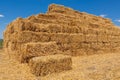 Bales of yellow straw laid out in a stack similar to a pyramid, farmland during harvest Royalty Free Stock Photo