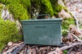 Balgale, Latvia - January 29, 2022: Green geocaching ammo box next to a mossy tree Royalty Free Stock Photo