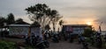 BALI, BERAWA BEACH, INDONESIA MARCH 2017: Local beach bar `Naked Coconut` at sunset time from car park with many scooters & beach Royalty Free Stock Photo