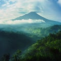 BALI ICONIC MOUNT AGUNG VOLCANO WITH CLOUDS DRIFTING AROUND SLOPES IMAGE Royalty Free Stock Photo