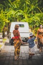 BALI, INDONESIA - APRIL 13, 2018: Asian kid with european young woman on balinese wedding day. Indonesian child.