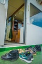 BALI, INDONESIA - APRIL 05, 2017: Different shoes waitting outside of the ferry boat pilot command cabin with view on