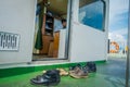 BALI, INDONESIA - APRIL 05, 2017: Different shoes waitting outside of the ferry boat pilot command cabin with view on