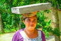 BALI, INDONESIA - APRIL 05, 2017: Women walk in the rice fields with basket on her head in Ubud, Bali, Indonesia