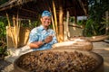 Bali - Indonesia 10.21.2015 - Balinese Indonesian man in traditional cloths smiling and checking luwak coffee seeds