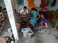 BALI, INDONESIA - CIRCA 2014: A batik workshop worker shows a tourist how to make a battic design on a piece of canvas near the to