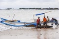 Bali, Indonesia - circa February 2017: Fishermen getting their jukung into the sea. A jukung is a traditional Balinese fishing Royalty Free Stock Photo