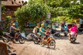 balinese road traffic, scooter drivers wait on crossroads.