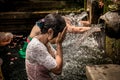 BALI, INDONESIA - DECEMBER 5, 2017: Holy spring water. People praying in the Tirta Empul temple. Bali, Indonesia. Royalty Free Stock Photo