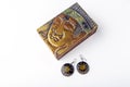 Bali, Indonesia - 06.20.2020: Handmade ethnic wooden earrings of antique metallic vintage casket on white background. Ancient