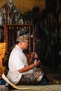 Bali - Indonesia - 10.22.2015: Indonesian musician dressed in traditional clothes playing a traditional string instrument: The