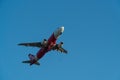BALI/INDONESIA-JUNE 06 2019: Air Asia, one of the airlines in Indonesia, is flying over the blue sky. Landing gear is in the