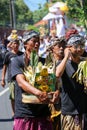 A balinese middle-aged man bring offerings on traditional funeral ceremony