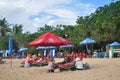 Balinese people service massage for Indonesian people and foreign travelers travel visit and swim playing relax on beach at Kuta