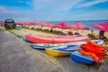 BALI, INDONESIA - MARCH 11, 2017: Beautiful sunny day with a row of red unmbrellas and some boats on the yellow sand, in