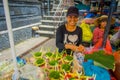 BALI, INDONESIA - MARCH 08, 2017: Unidentified woman do an arrangement of flowers inside of a box made of leafs in a