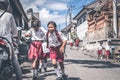 BALI, INDONESIA - MAY 23, 2018: Group of balinese schoolboys in a school uniform on the street in the village.