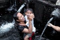 BALI, INDONESIA - MAY 5, 2017: Holy Spring Water Tirta Empul Hindu Temple , Bali Indonesia. Woman with son. Royalty Free Stock Photo