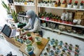 BALI/INDONESIA-MAY 25 2019: A Muslim businesswoman is selling succulent plants on internet. She has a clean and white workshop.