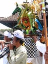 People with wooden statue of winged green horse in Balinese ritual event parade at Hindu temple