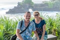 BALI, INDONESIA - MAY 4, 2017: Woman and her son on a background of Pura Tanah lot temple, Bali island, Indonesia. Royalty Free Stock Photo
