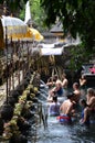 Indonesian and tourism pray and bath themselves in the sacred waters of the fountains, in Tirta Empul, Bali