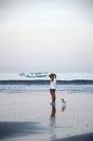 Woman with dogs walking at tropical beach in the morning in Bali, Indonesia