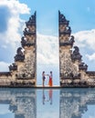 Tourists take photos at the gates of Pura Lempuyang Luhur Temple in Bali, Indonesia