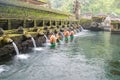 Bali, Indonesia - september 01,2022: Unidentified tourist at the holy spring water is praying at Pura Tirta Empul temple during a Royalty Free Stock Photo