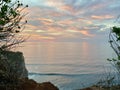 Bali\'s Cliffside Canvas: Sunset Magic Paints the Sky in Hues of Yellow, Orange, and Red, Above Turquoise Waters
