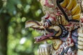 Balinese ancient colorful bird god Garuda with wings, closeup. Religious traditional statue from wood. Wooden old curved figure of Royalty Free Stock Photo