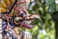 Balinese ancient colorful bird god Garuda with wings, closeup. Religious traditional statue from wood. Wooden old curved figure of