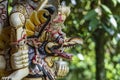 Balinese ancient colorful bird god Garuda with wings, closeup. Religious traditional statue from wood. Wooden old curved figure of