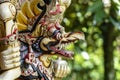 Balinese ancient colorful bird god Garuda with wings, closeup. Religious traditional statue from wood. Wooden old curved figure of Royalty Free Stock Photo