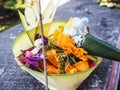 Balinese canang sari offering with orange flowers and incense