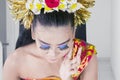 Balinese dancer applying foundation on her cheek Royalty Free Stock Photo