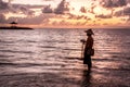 Balinese fisherman fishing on a beach at sunrise.