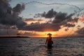 Balinese fisherman fishing on a beach at sunrise.