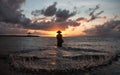 Balinese fisherman fishing on a beach at sunrise.