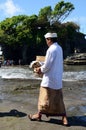 Balinese man bringing his offerings to attend the prayer at Tanah Lot temple, Bali